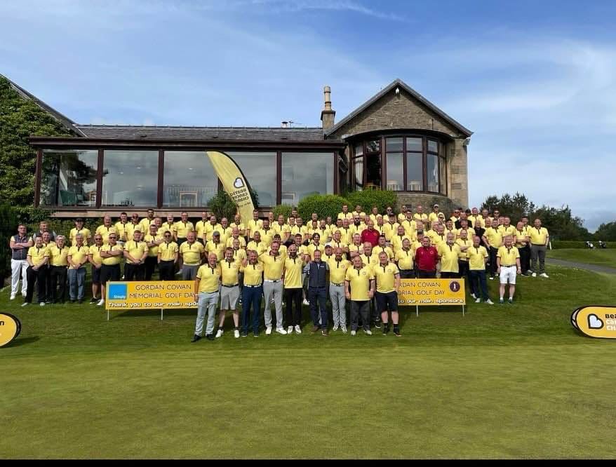 Golfers in yellow shirts outside the clubhouse