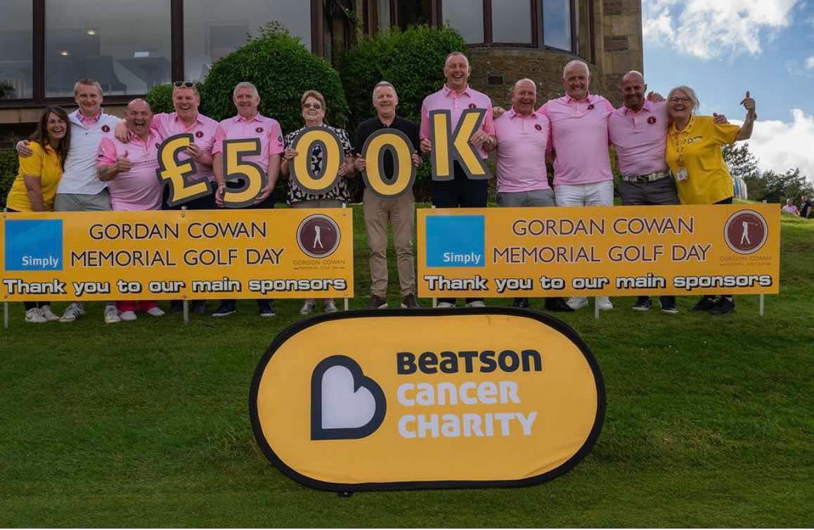 Supporters holding £500K letters beside a Beatson Cancer Charity sign