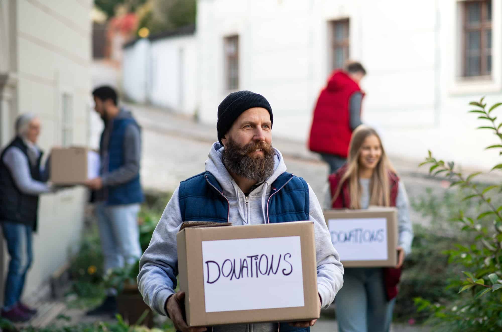 diverse-group-of-volunteers-with-donation-boxes-standing-outdoors-social-care-and-charity-concept.jpg